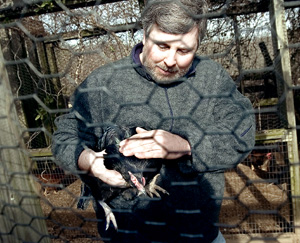 Ian Keats of Charlottesville pets a rooster at Crossing Creeks. The mental health facility has been open since 2004.